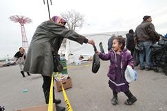 Safiyya giving necessities to a young child in Coney Island