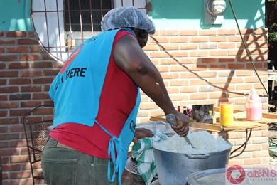 Jamaican volunteer from Feeding of the 5000 making the rice.